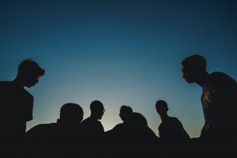young people silhouetted against a setting sun