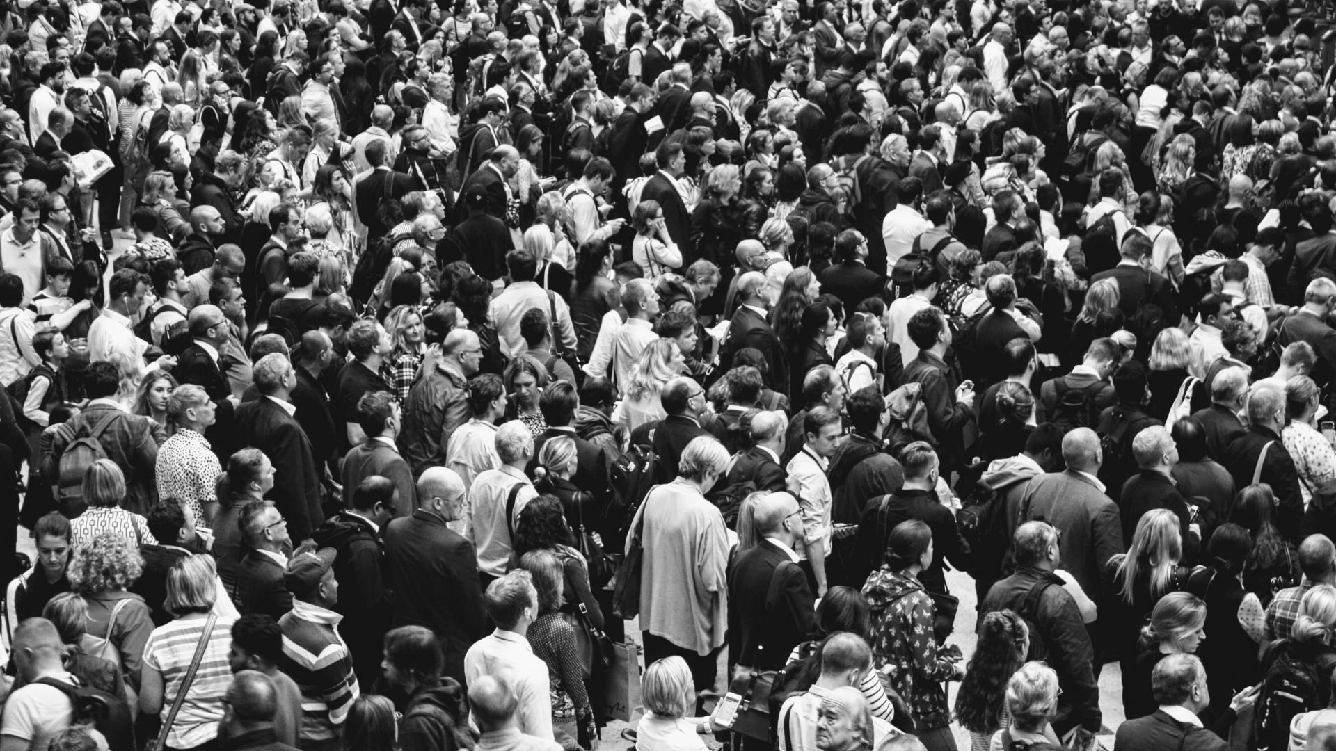 a black and white image of a dense crowd of people